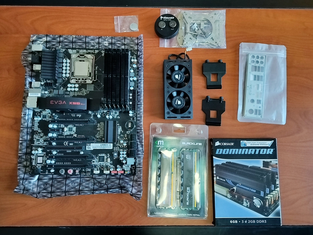 Motherboard, RAM, RAM cooler, and CPU waterblock on table.
